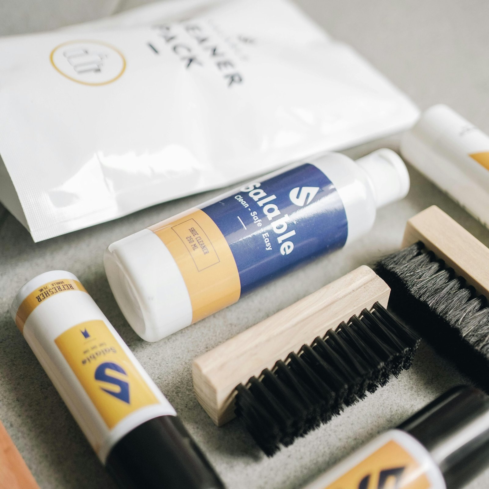 Close-up of a shoe care kit with brushes and cleaners, ideal for maintaining footwear.